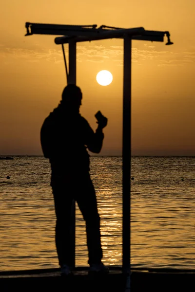Prachtige silhouetten bij zonsondergang gouden zeewater — Stockfoto