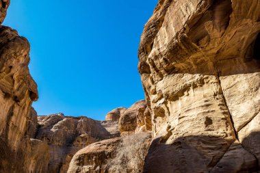 Al-Siq adındaki nefes kesici doğal vadi, su akıntısı tarafından kızıl uçurumlara oyulmuş, Petra antik şehir kompleksi ve turistik ilgi merkezi, Ürdün Haşimi Krallığı. Güneşli kış günü, bulutsuz gökyüzü