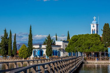 PORTO LAGOS, GREECE - 29 Kasım 2019: Turistler, Yunanistan 'ın kuzeyinde Vistonida Gölü, Porto Lagos, Xanthi bölgesi üzerine inşa edilen güzel St. Nicholas manastırının tadını çıkarıyorlar.