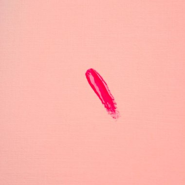 Pembe kağıtta parlak kırmızı ruj lekesi, üst görüş, minimalizm, güzellik konsepti.