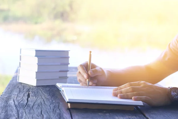 Fotoğraf adam sağ üstünde sabah sahne ile açık alanda küçük defter günlük yazma stok — Stok fotoğraf