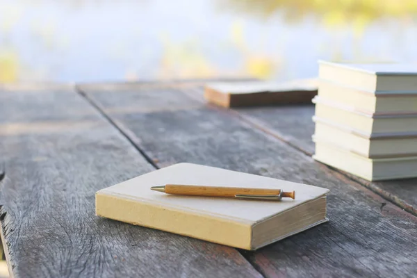 Старая книга с карандашом, в парке. зеленый фон природы — стоковое фото