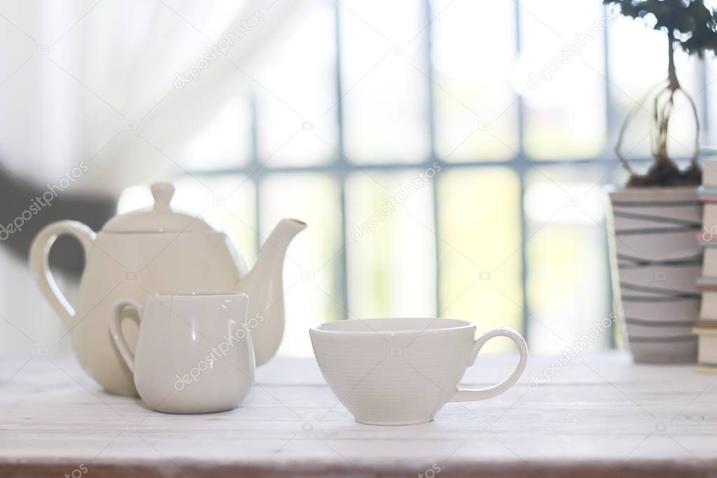 Stock Photo Little white tea cup and a kettle isolated over side windows background