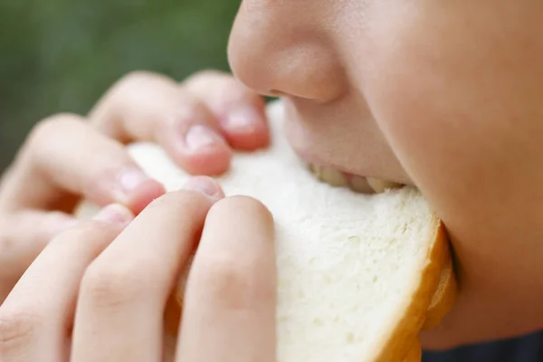 Stock Photo Ragazza asiatica mangiare pane o cibo malsano, concetto di stile di vita — Foto Stock