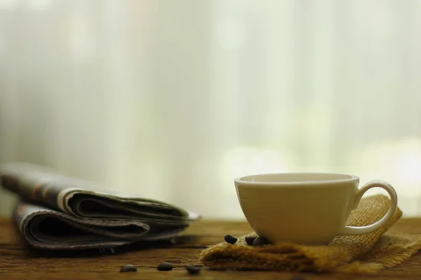 Stockfoto - kopp kaffe och tidning på träbord — Stockfoto