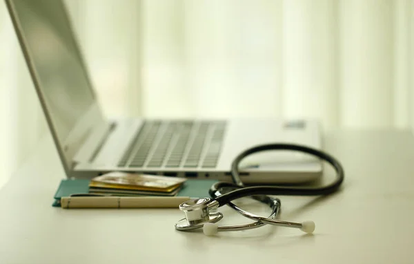 Foto de stock - Un estetoscopio médico y norebook en una tabla blanca —  Fotos de Stock