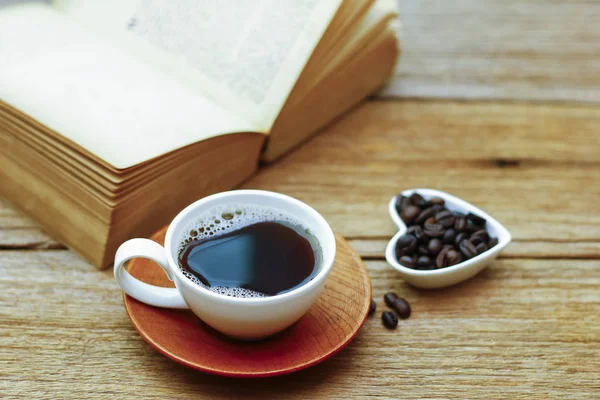 Foto de stock - Taza de café y libro sobre mesa de madera - vintage (retro ) —  Fotos de Stock