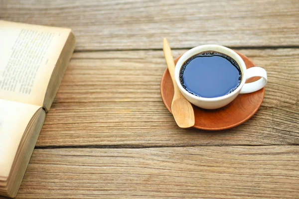 Archivfoto - aufgeschlagenes Buch mit Tasse Kaffee auf rustikalem Holzboden — Stockfoto