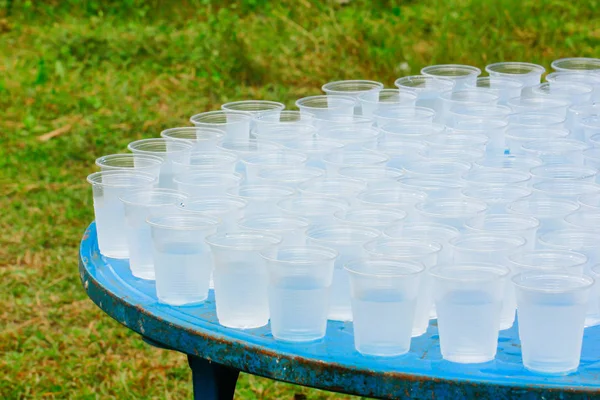 Stock Photo - Verres en plastique d'eau sur table en bois pour les services Images De Stock Libres De Droits