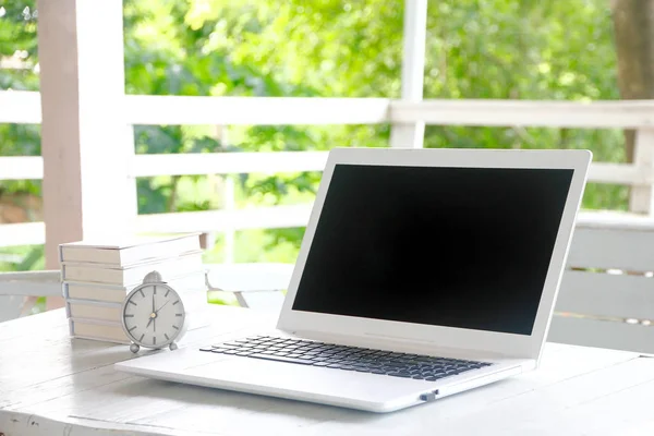 Zdjęcie stockowe Laptop pusty ekran na szczycie naturalnym drewnianym stole i retro tło białe i dzikiej przyrody. Za projekt graficzny wyświetlacz — Zdjęcie stockowe