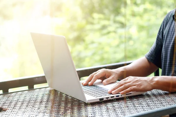 Zdjęcie stockowe zbliżenie ręki człowieka, wpisując laptop albo Notatnik siedzi w jego stylu vintage miejsce pracy — Zdjęcie stockowe