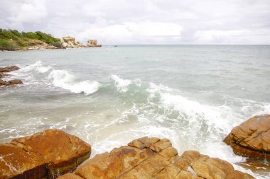 Deniz dalgaları taşların üzerinde yuvarlanıyor