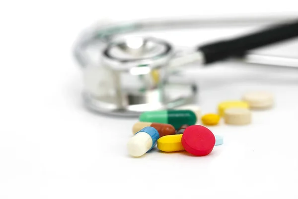 Orvosi, orvosi sztetoszkóppal és tabletták fehér háttér. — Stock Fotó