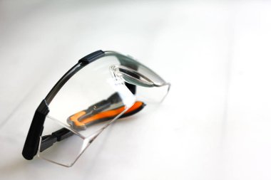 Beyaz ahşap masa arka plan siyah plastik koruyucu iş gözlüğü.