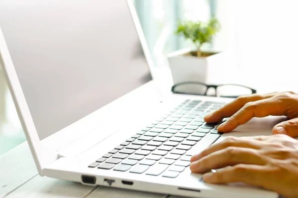Ręce człowieka za pomocą laptopa z pustego ekranu na biurku w domu inter — Zdjęcie stockowe