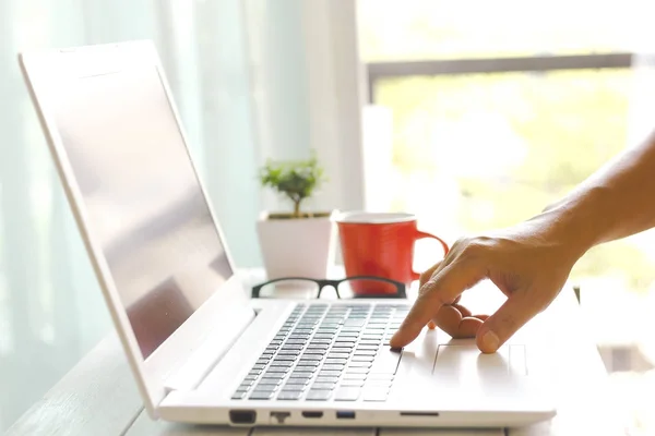 Männerhände mit Laptop mit leerem Bildschirm auf Schreibtisch in der Wohnung — Stockfoto