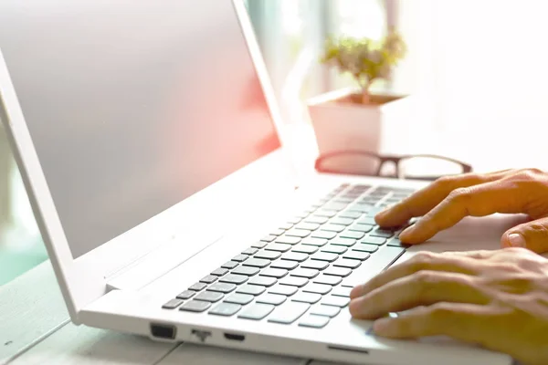 Männerhände mit Laptop mit leerem Bildschirm auf Schreibtisch in der Wohnung — Stockfoto