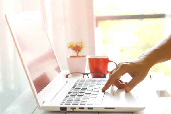 Man's hands using laptop with blank screen on desk in home inter — Stock Photo, Image