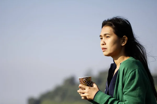 Mavi gökyüzü karşı kadının elinde kahve — Stok fotoğraf