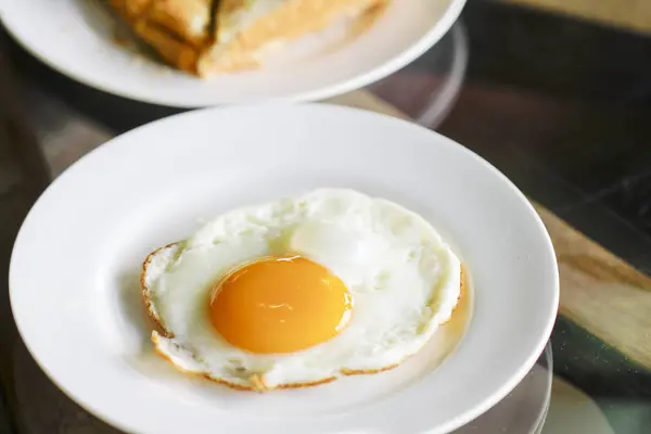 Fried eggs with toasts and coffee, traditional breakfast