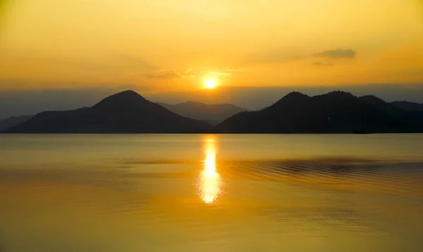 Nascer do sol sobre o lago e montanhas — Fotografia de Stock