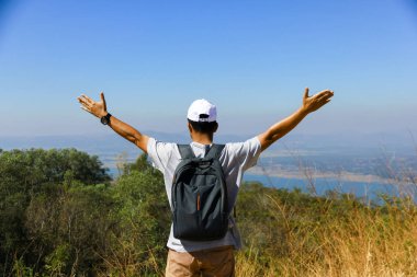 Adam dağın üzerinde mavi gökyüzü ayakta