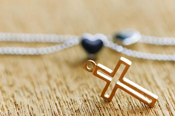 Colar crucifixo dourado na placa de madeira — Fotografia de Stock