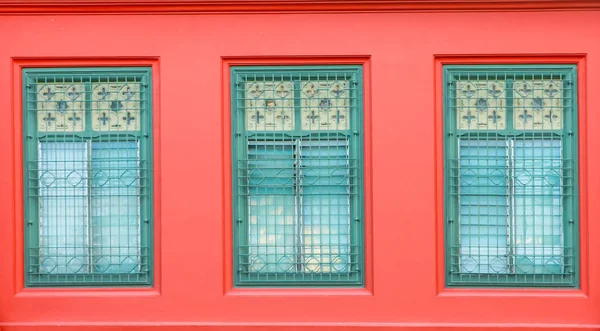 Eski yeşil cam, kırmızı bina. Eski stil pencere Izgaralar. ve — Stok fotoğraf