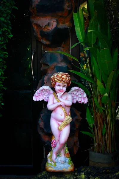 站在花园里的粉红色婴儿天使雕像。选择性重点和 — 图库照片