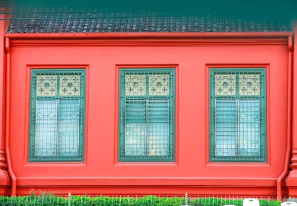 Old green window, on red Building. Old style window grilles. and