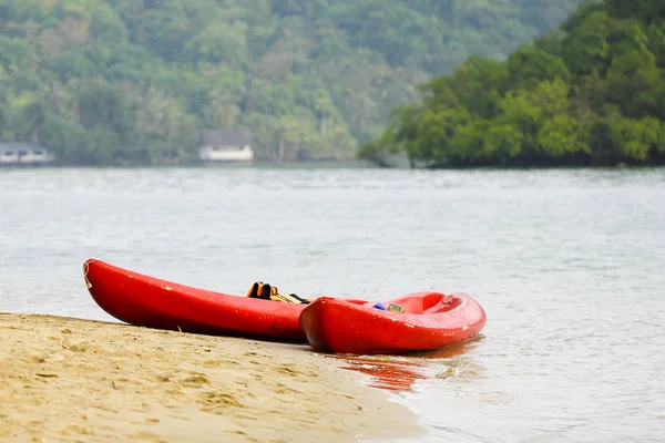 Rafting on kayaks. Red kayaks at the lakeside, on the tropical b — Stock Photo, Image