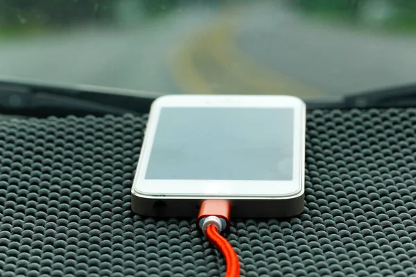 Chargement smartphone avec chargeur en voiture sur la console — Photo