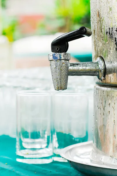 Vatten droplet på rostfritt stål med ett glas vatten på det ta — Stockfoto