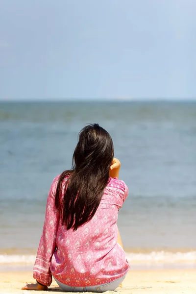 Achteraanzicht van een jonge vrouwen denken alleen en kijken naar de zee — Stockfoto
