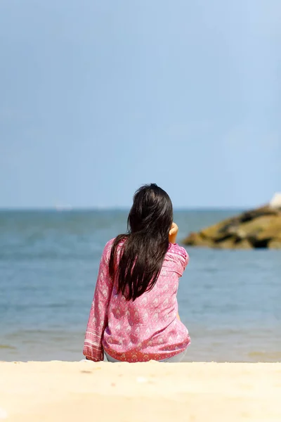 Achteraanzicht van een jonge vrouwen denken alleen en kijken naar de zee — Stockfoto