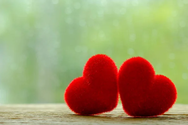 Close-up de dois corações vermelhos na mesa de madeira contra o gre desfocado — Fotografia de Stock