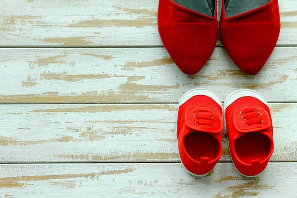 Две красные туфли или кроссовки матери или отца и ребенка в лесу — стоковое фото
