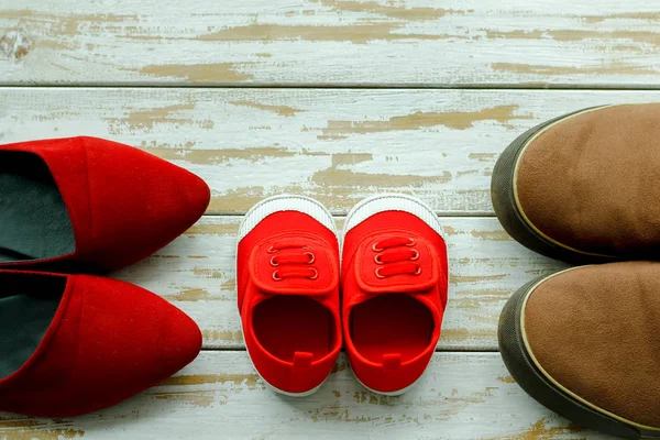 Twee rode schoenen of sneakers van moeder of vader en kind op woode — Stockfoto