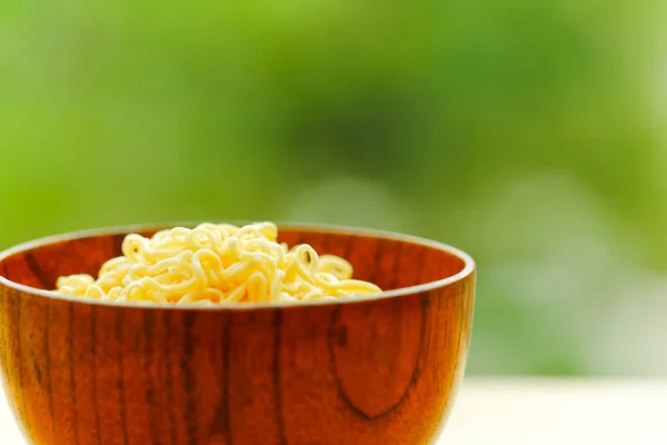 Fideos en cuenco de madera en la mesa con fondo verde . —  Fotos de Stock