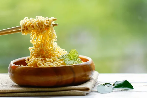 Instant Noodles zetten houten tafel op groene achtergrond. — Stockfoto