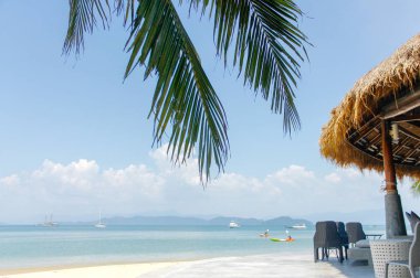 Bir şezlong altında deniz ve gökyüzü ile kum plajındaki