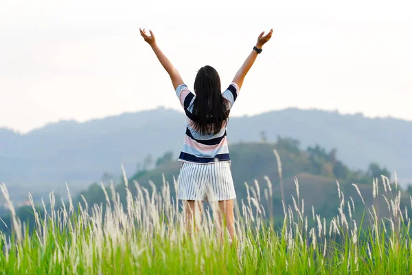 Woman holds arms on top of hill — Stock Photo, Image