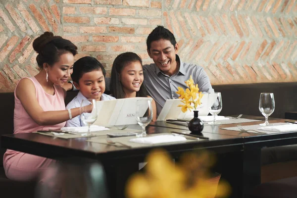 Family reading menu at restaurant — Stock Photo, Image