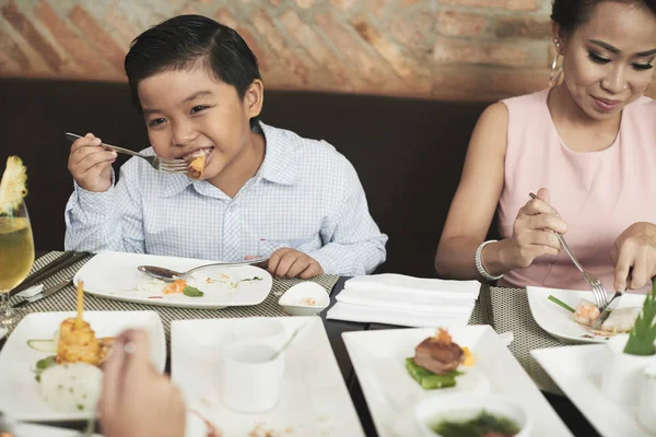 Boy enjoying meal in restaurant — Stock Photo, Image