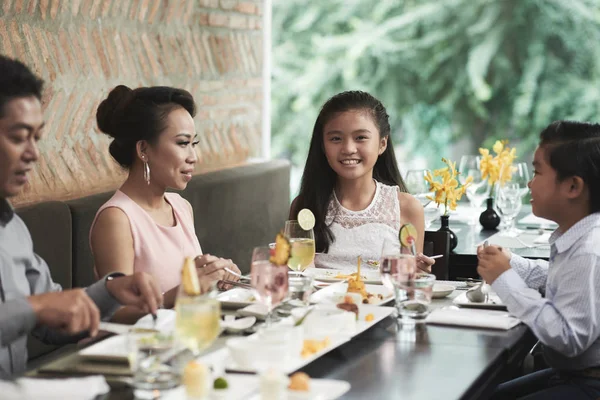 Tyttö lounastaa perheensä kanssa — kuvapankkivalokuva