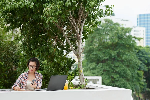 Vrouw die op laptop in park werkt — Stockfoto