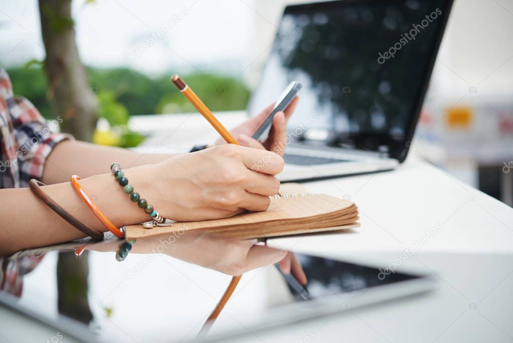 woman taking notes in notepad