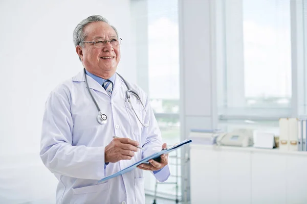 Médico sênior segurando história médica — Fotografia de Stock