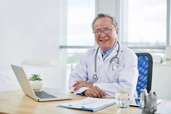 Arts werkzaam aan tafel in kliniek — Stockfoto