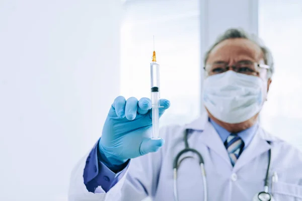 Médico con jeringa llena de medicamentos — Foto de Stock